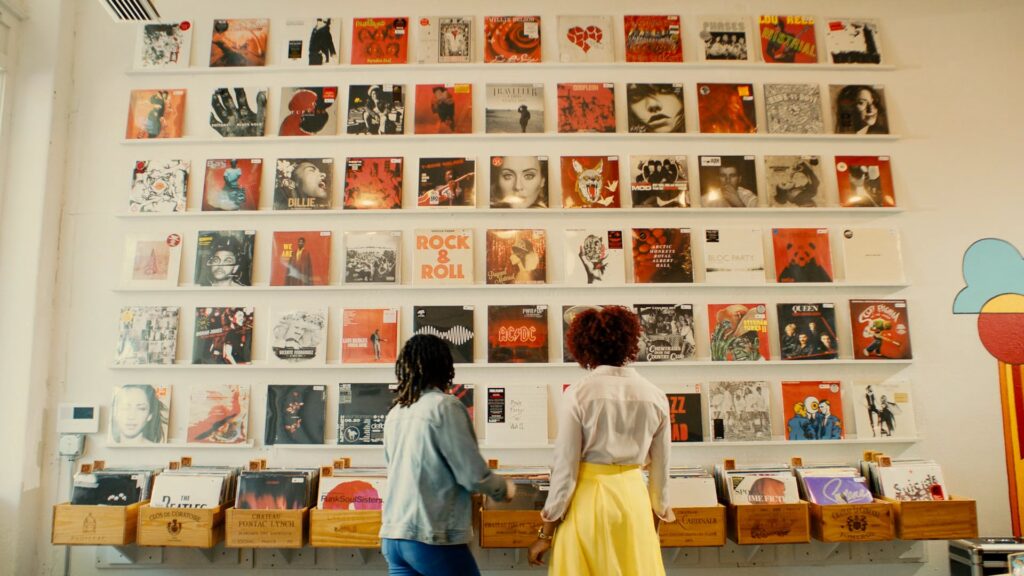 Two women browsing vinyl records on a shop wall