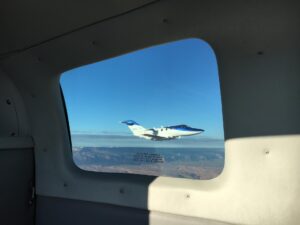 HondaJet seen through an airplane window over desert terrain