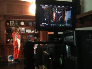 Cinema camera filming an actress in an orange flight suit