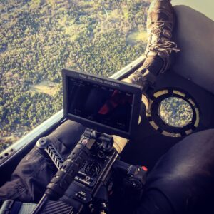 Cinema camera inside a helicopter with forest visible out the door