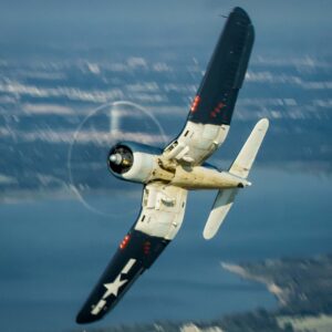 Vintage F4U Corsair banking over water