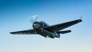 Navy-blue Avenger torpedo bomber in flight