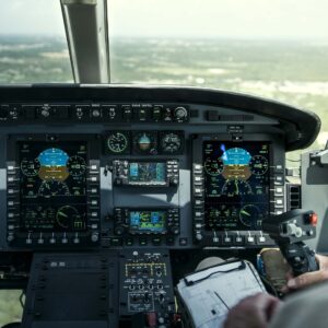 Helicopter glass cockpit with digital flight displays and a hand on the cyclic