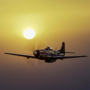 Silver P-51 Mustang with a red nose flying at sunset