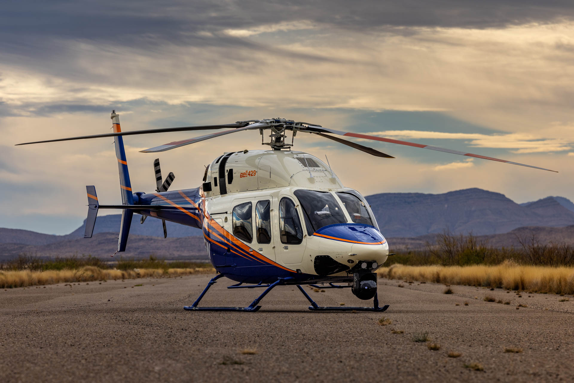 Bell 429 helicopter parked on a desert ramp at sunset