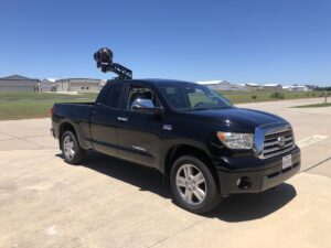 Cinema camera rigged to the hood of a pickup truck for a driving shot