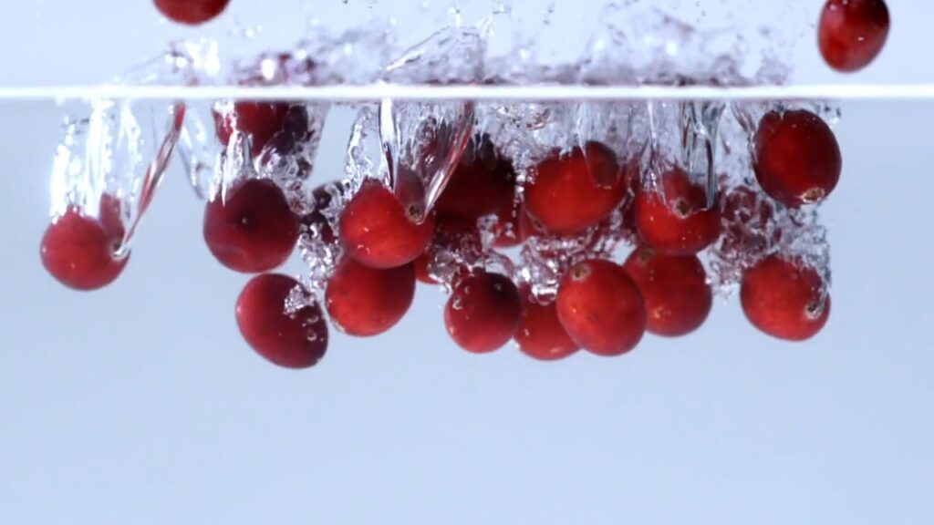 Cherries splashing into water in a slow-motion product shot