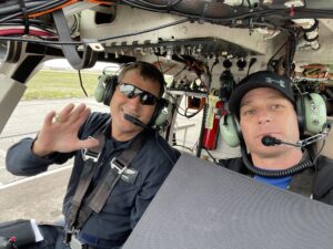 Two crew members in a helicopter cockpit before takeoff