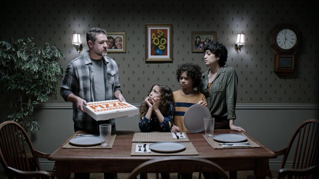 Family gathered around a dinner table with a birthday cake