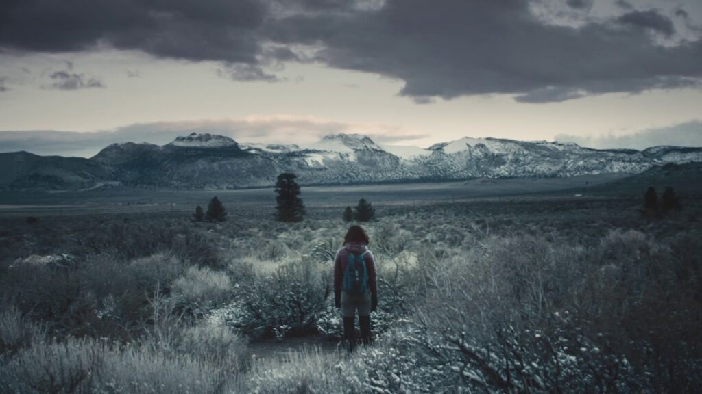 Girl standing alone in a wide open prairie