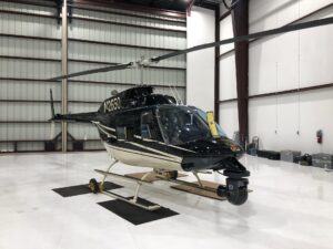 Helicopter parked inside a lit hangar