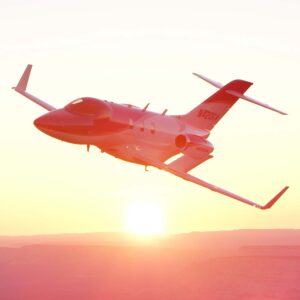HondaJet climbing over desert at sunset