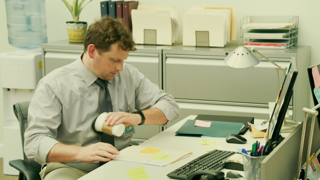 Man working at a paper-covered office desk
