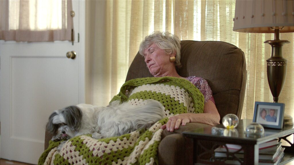 Older woman resting in an armchair in a warm-lit living room