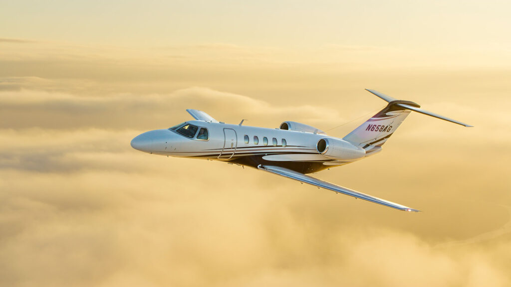 Business jet in flight above the clouds during aerial photography