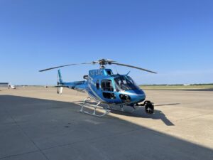 Blue helicopter N172AC with a camera gimbal on the tarmac