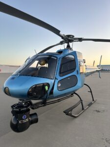 Light blue helicopter with a GSS gimbal on the tarmac